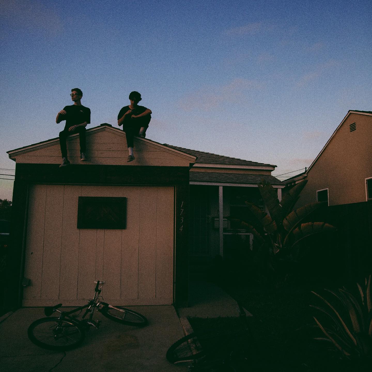 band members sitting on a rootop at sunset